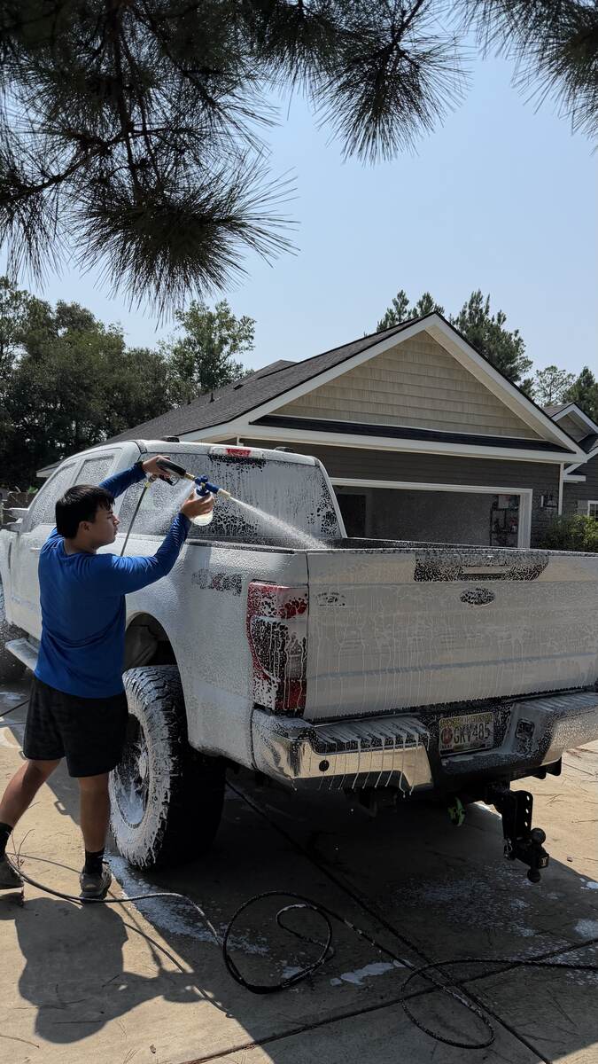 Trujillo's crew member foam-washing a Ford F-150 truck bed