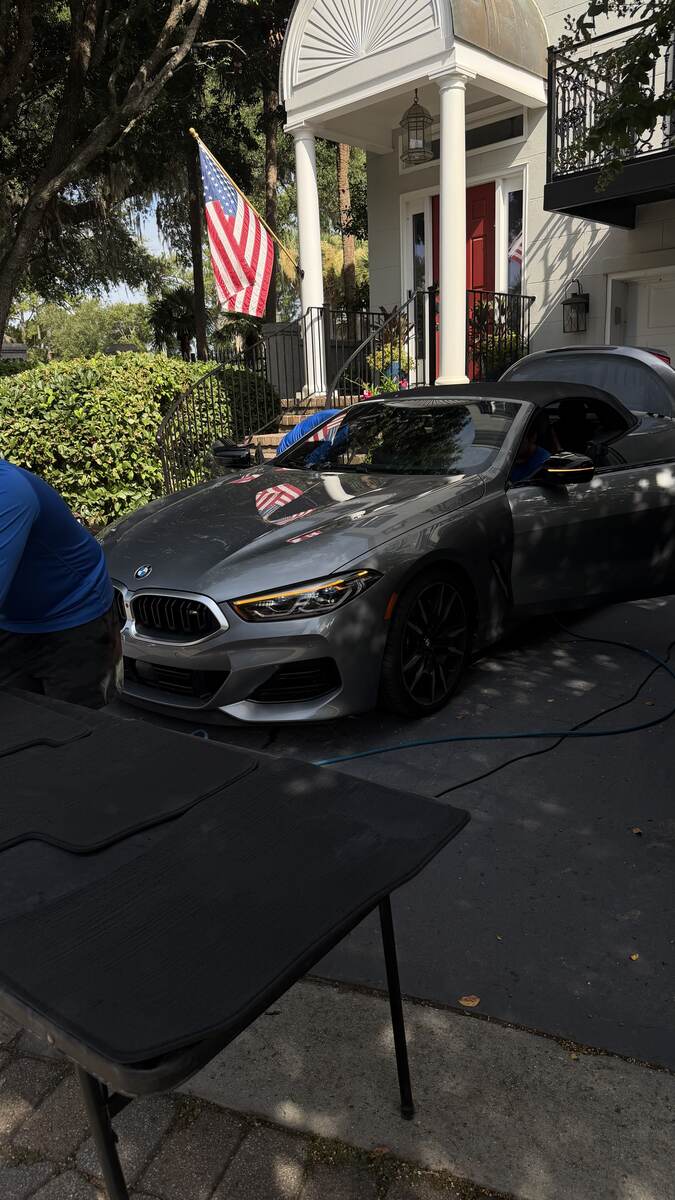 Trujillo's Cleaning Services detailing a BMW 8 Series convertible in a Savannah driveway