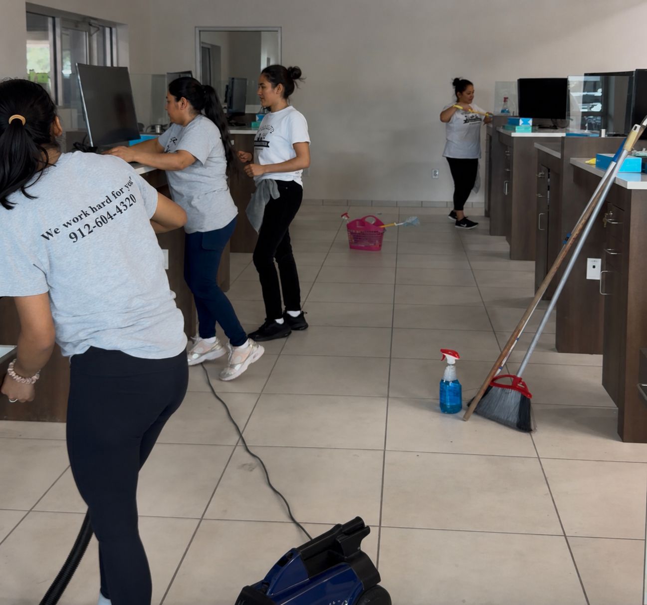 Trujillo's interior cleaning team wiping down desks and vacuuming a commercial space