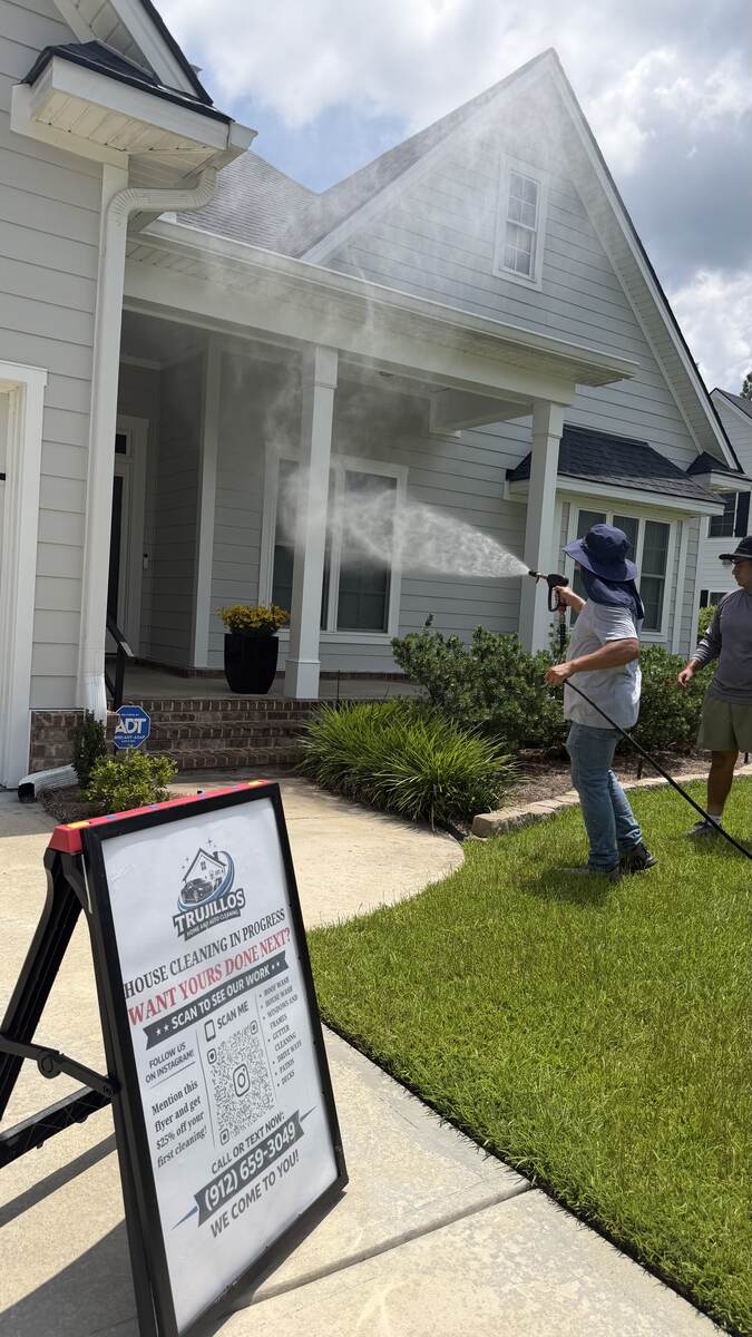 Trujillo's crew pressure washing a home's roofline and siding in Savannah, GA